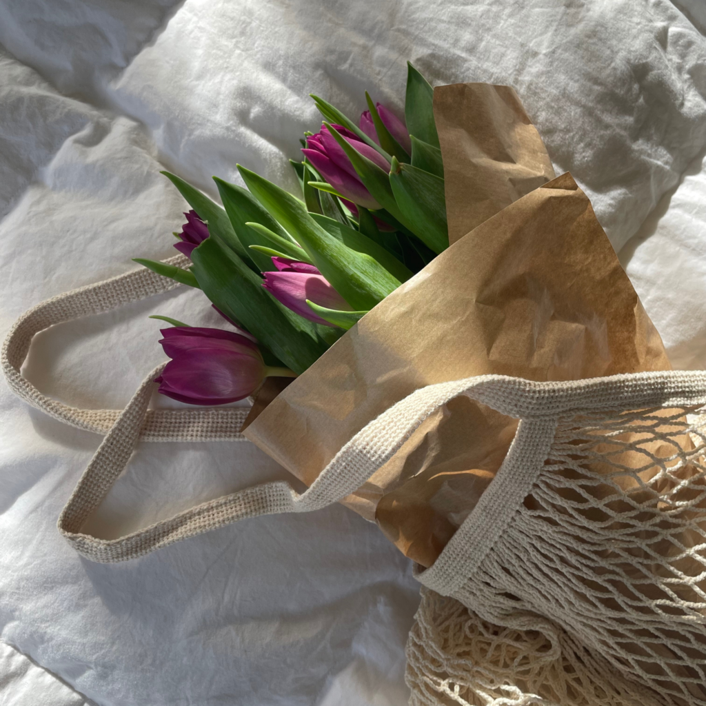 tulips in wrapping paper in straw bag
